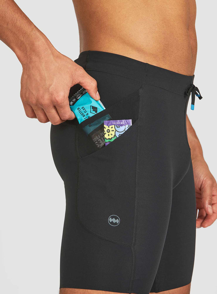 Side profile of Janji men's half tights showing stash pockets and 8-inch cut